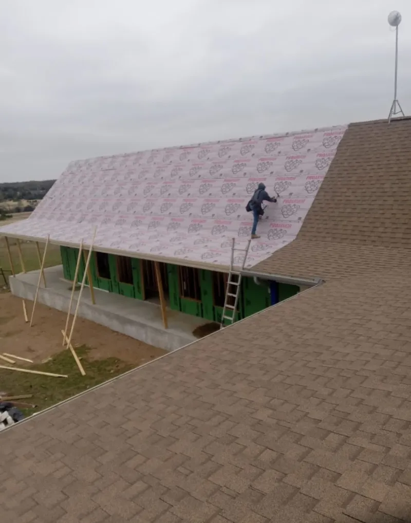 Worker preparing underlayment for a metal roof installation in Lansdale